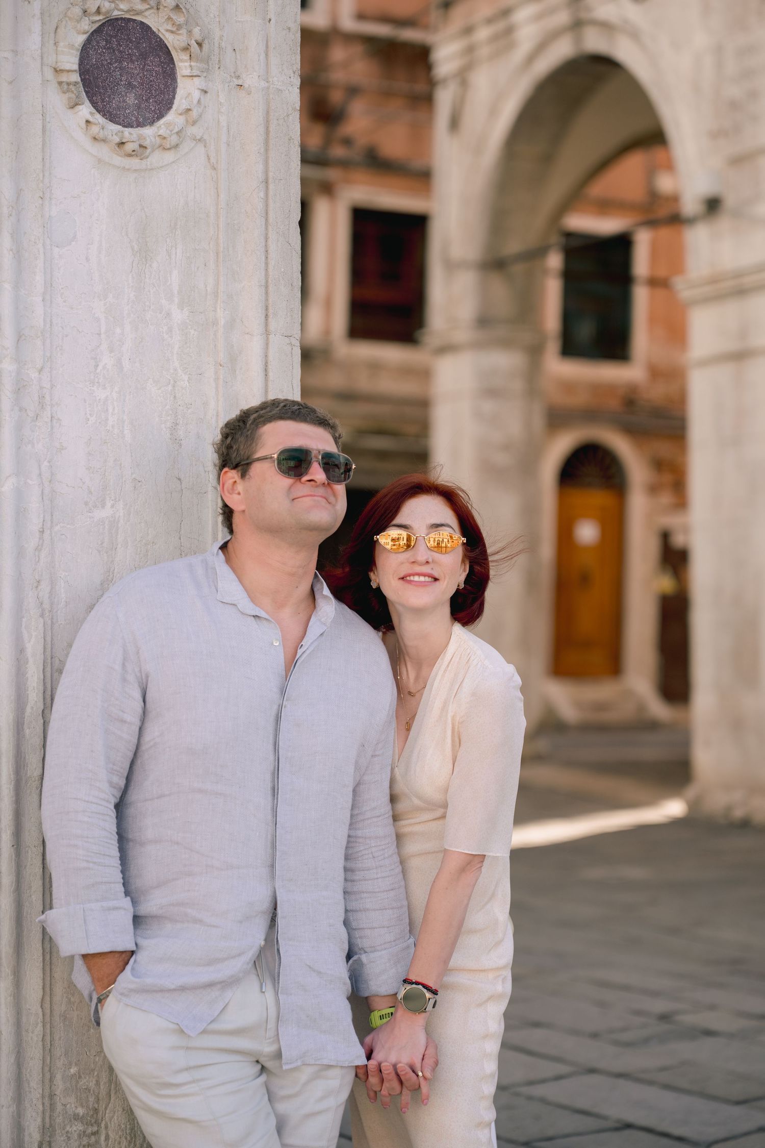 Black and white photo of a couple posing in front of the Rialto Bridge in Venice, Italy.