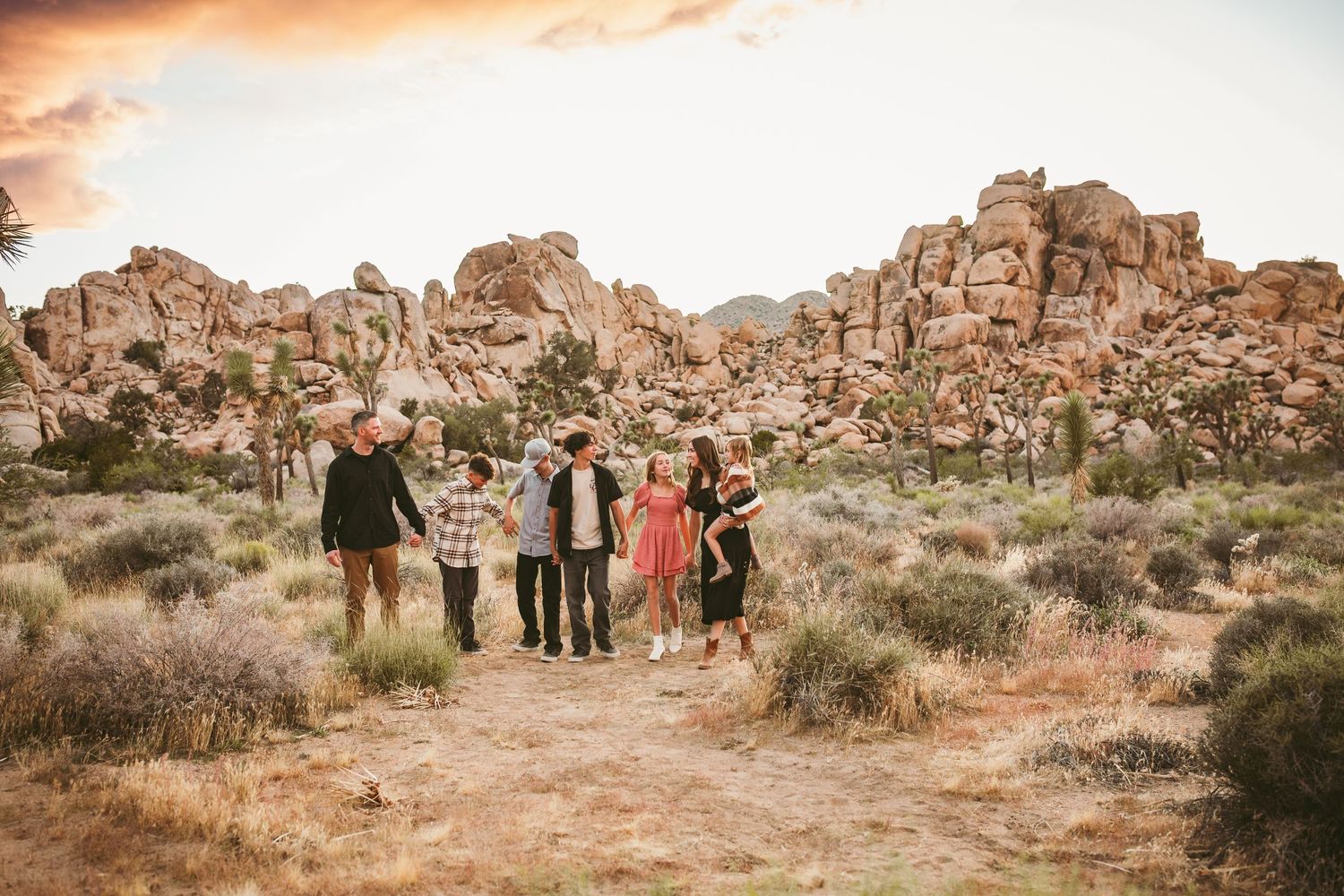 a large family walks through the trees in joshua tree national park