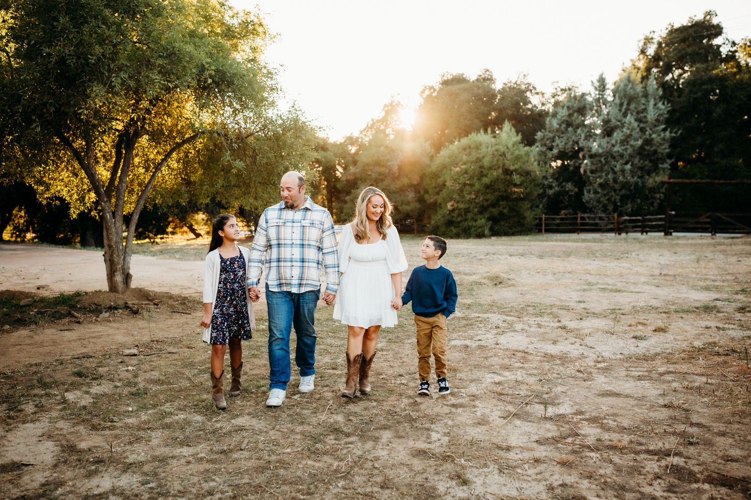 a beautiful family of four walks through a field in yucaipa ca