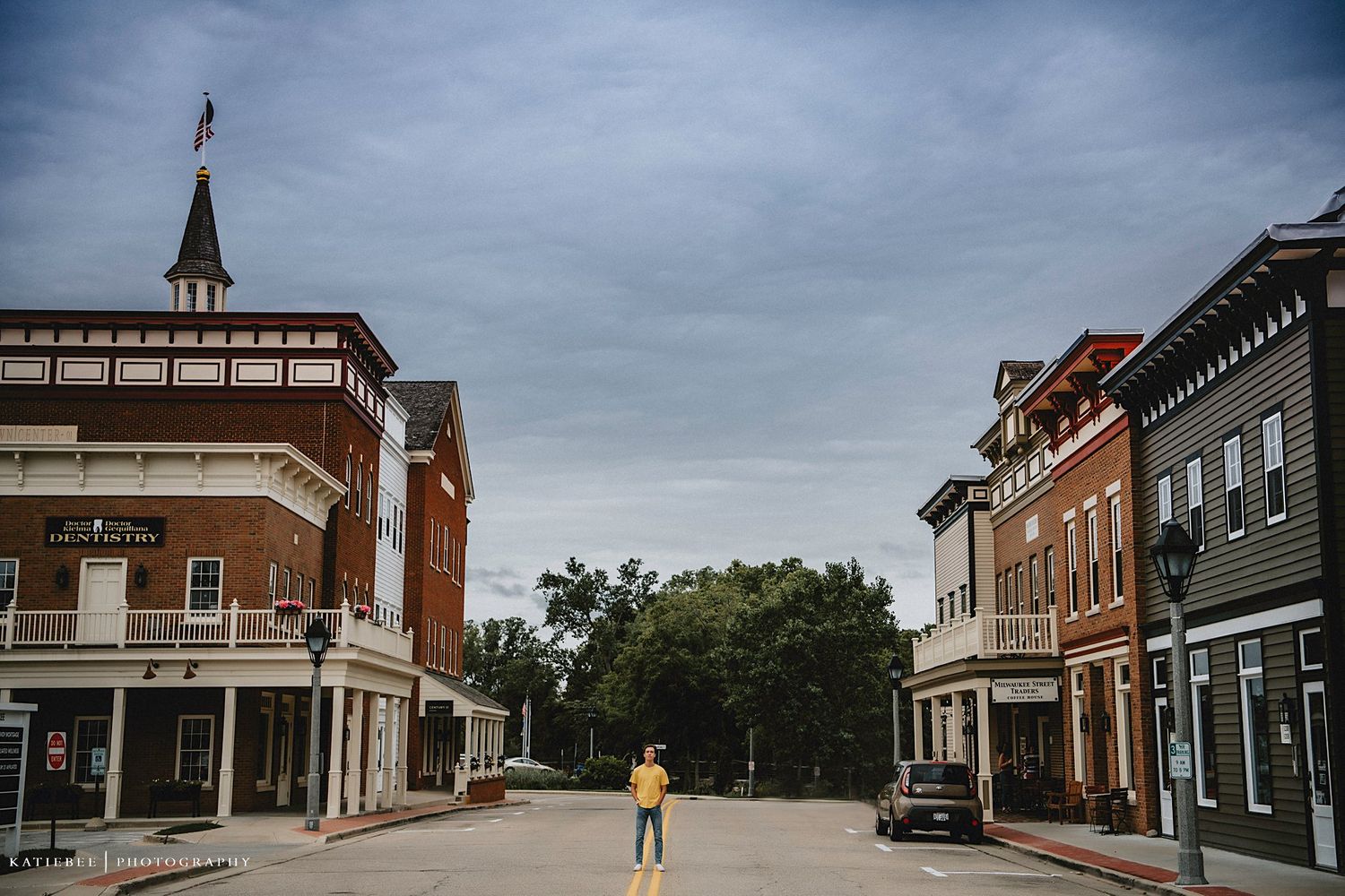 Historic small town main street view with brick buildings and cloudy sky.