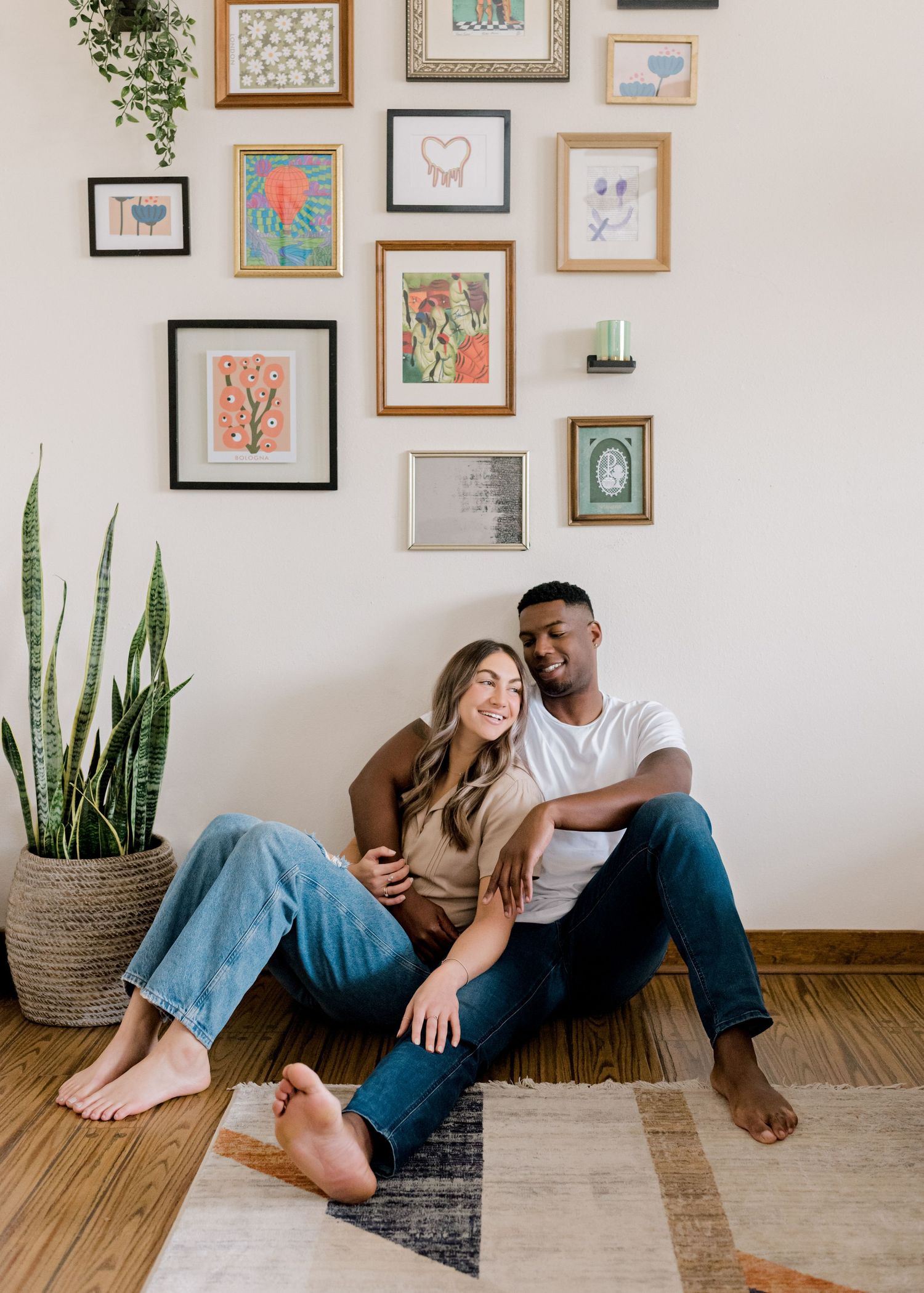 couple sitting together on the floor, cuddled together as they both smile