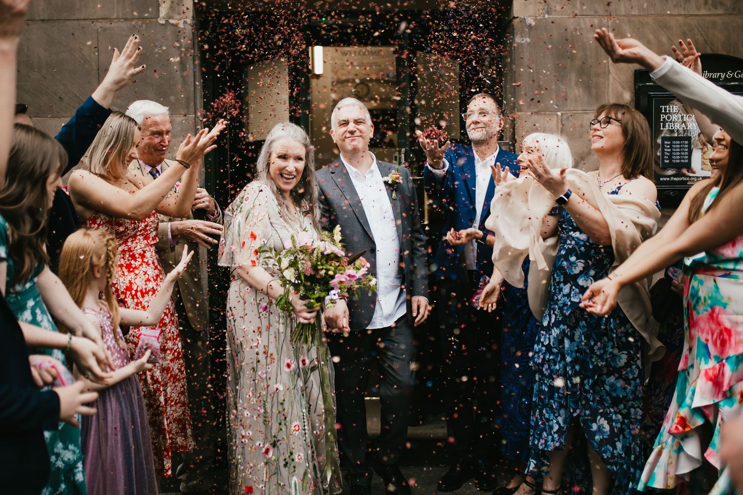 bride groom confetti at the portico library in Manchester by lancashire wedding photographer