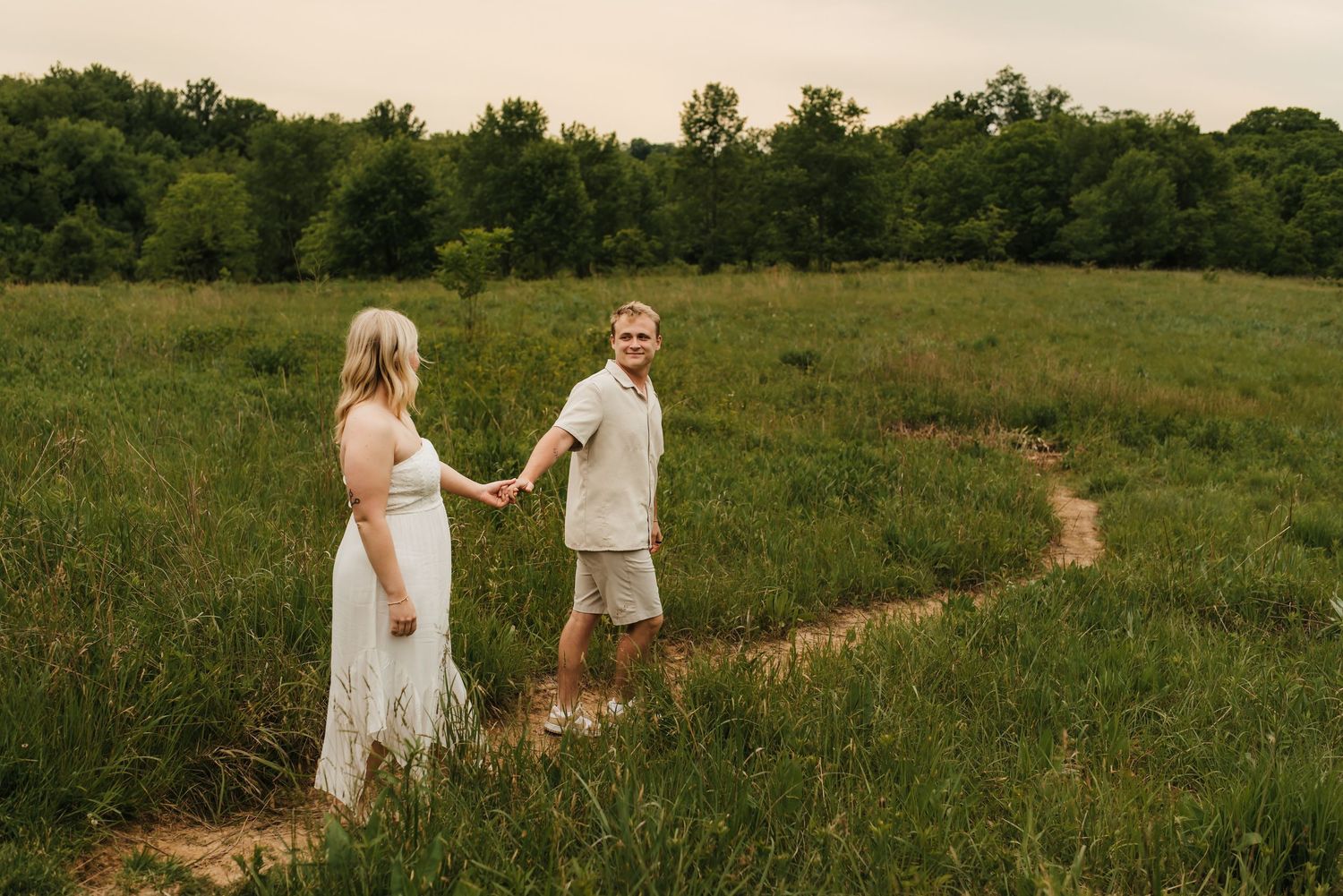 Couple holding hands during an engagement session outdoors.