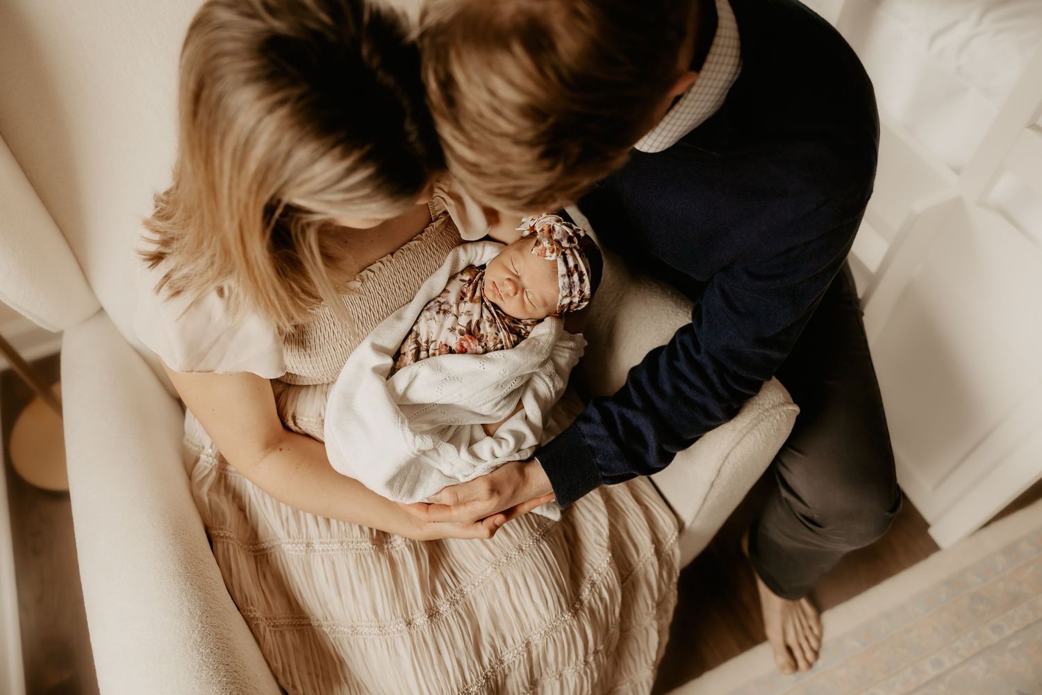 Parents hold their baby girl as a Honolulu Newborn Photographer photographs their newborn session.