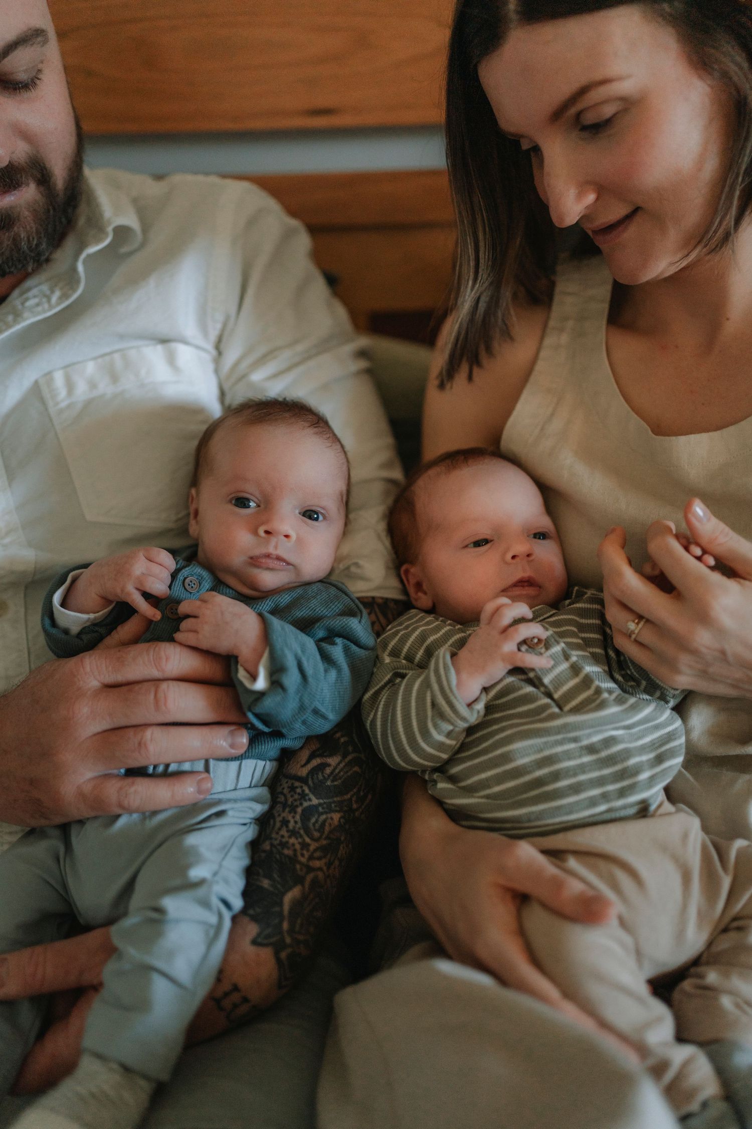 A series of tender moments showing parents cradling infants wearing striped clothing on a couch.