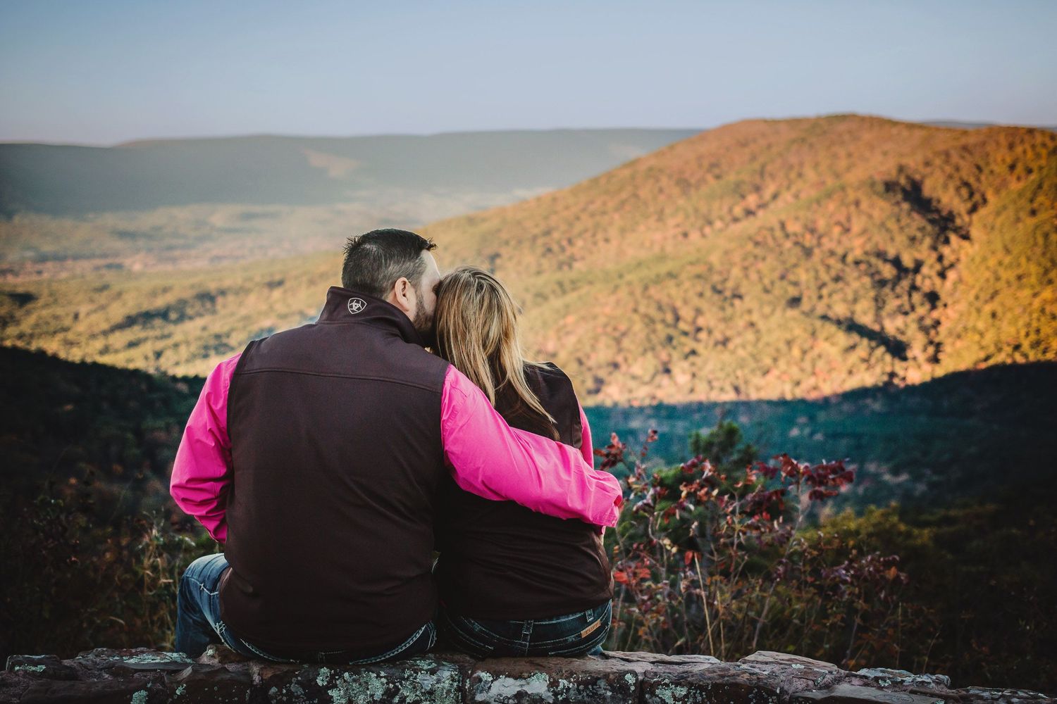 Larry and Misty at the Eagleton Vista stone wall in Arkansas. A golden morning adventure engagement session by Wolfpack Wedding Co.