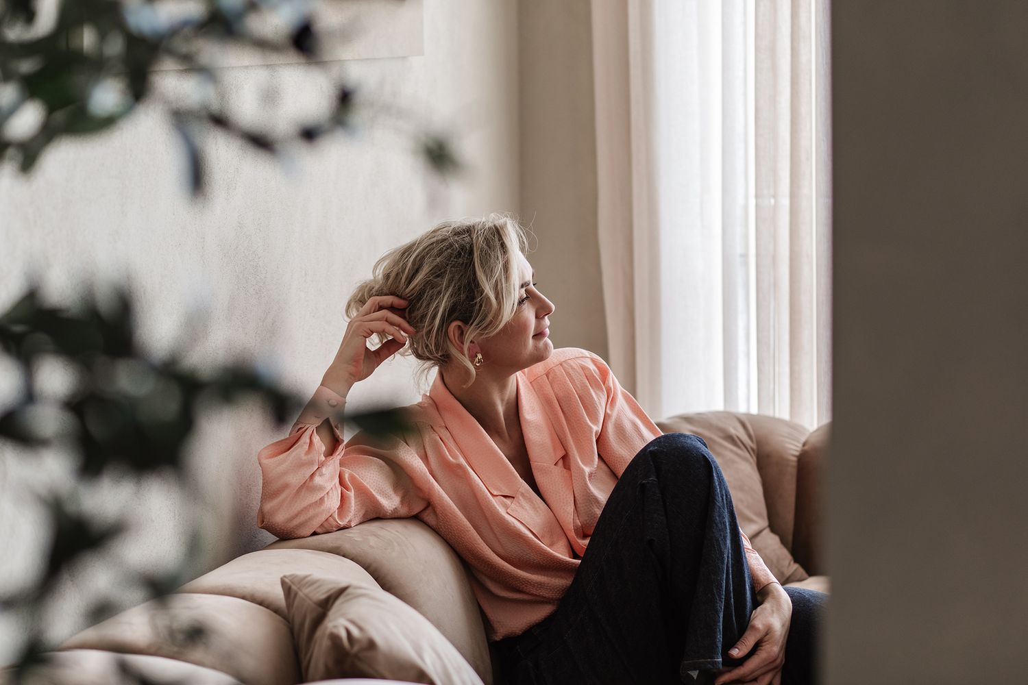 Een personal branding shoot van een vrouwelijke ondernemer die ontspannen zit op de bank.