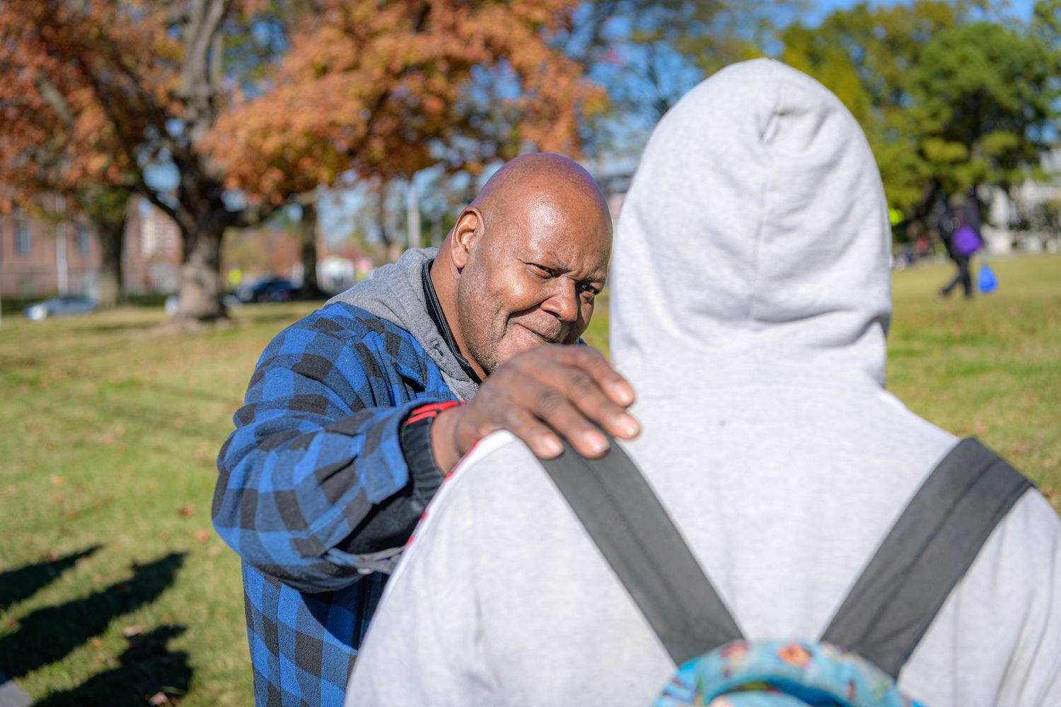 A series of outdoor photos showing two people embracing and enjoying a sunny day in a grassy park setting.