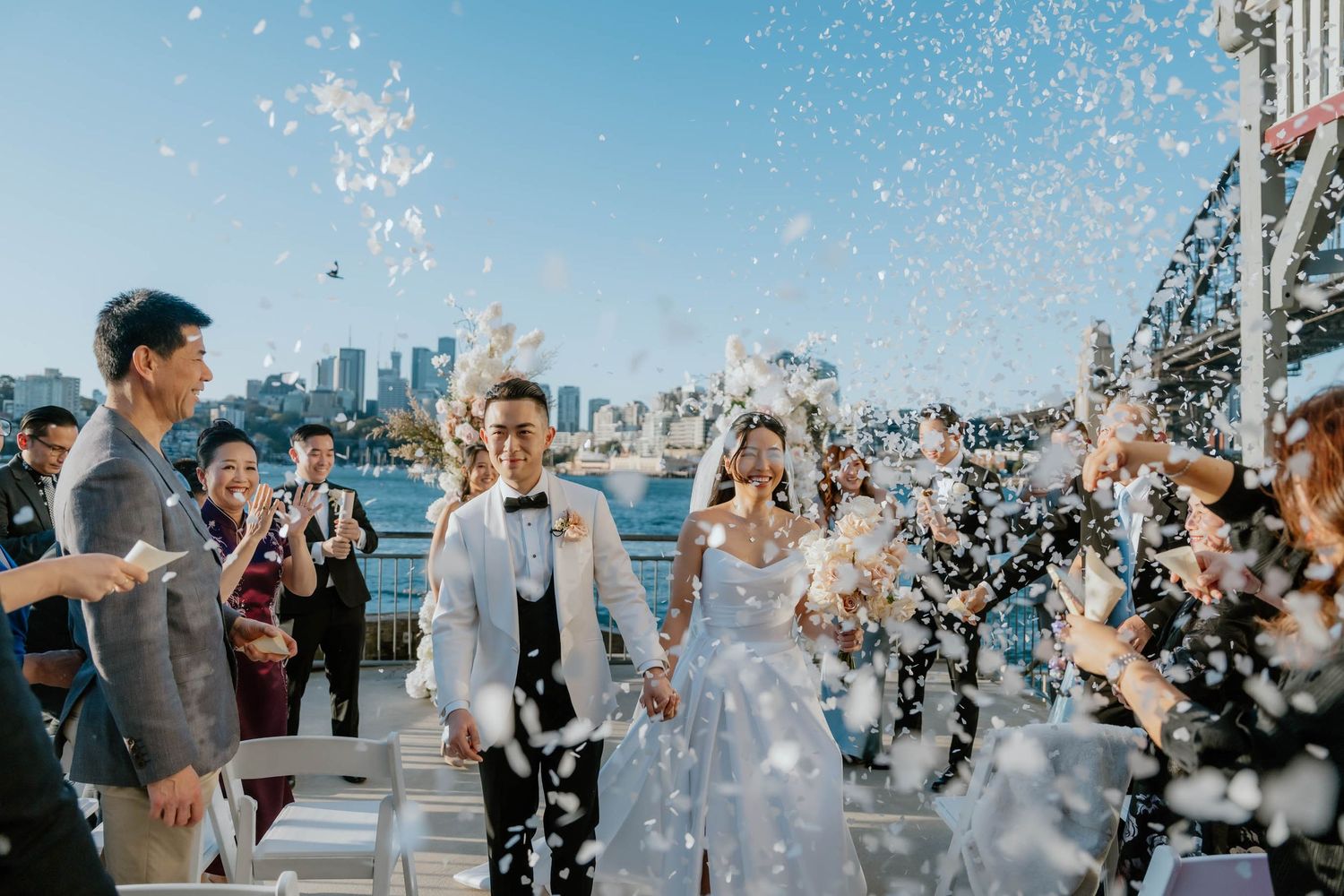 Joyful celebration on a rooftop venue with confetti falling and city skyline views in the background.