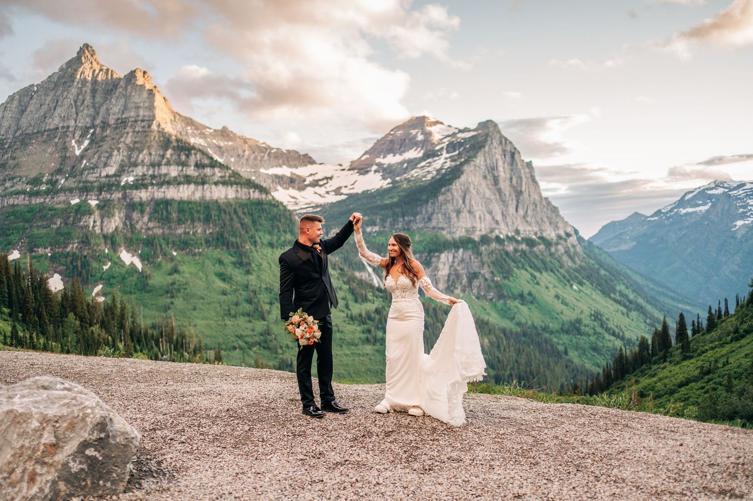 Scenic mountain elopement photos captured in Glacier National Park during golden hour with dramatic peaks in background.
