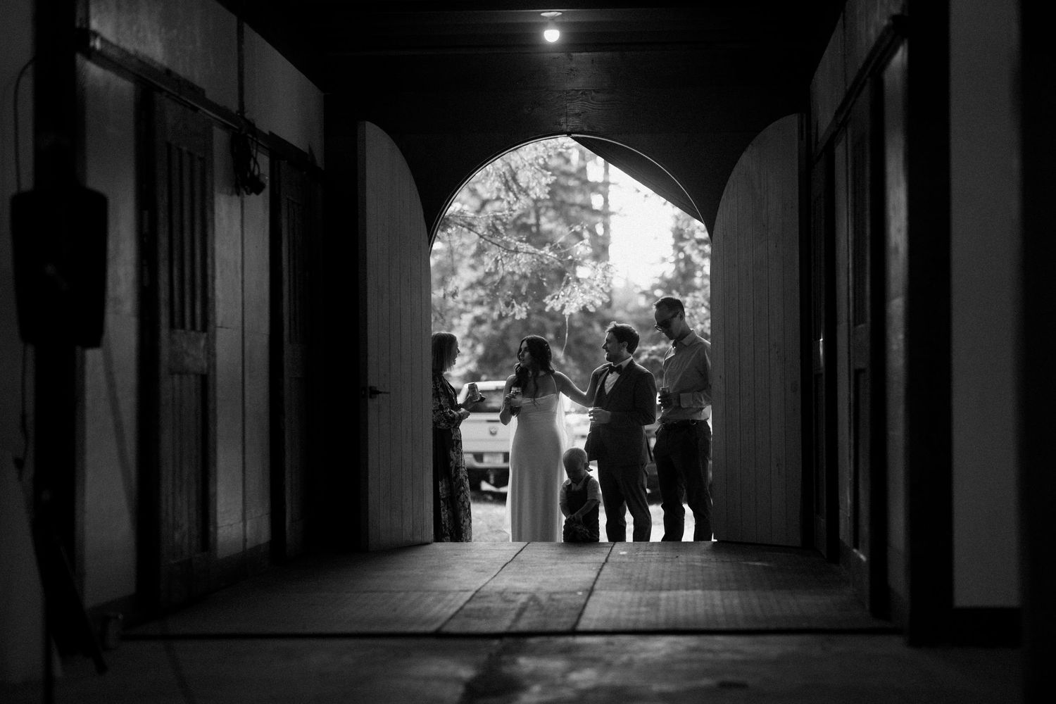 Dark corridor with arched walkway and silhouettes of people in the distance.