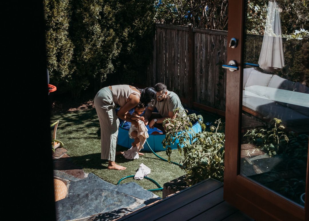 People working together in a backyard garden on a sunny day.