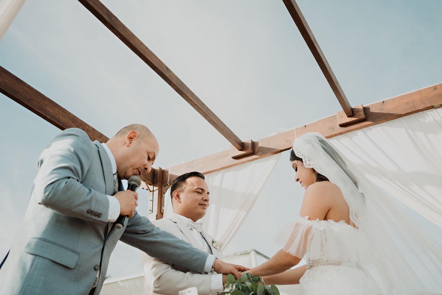 The pastor blessing the couple during the religious ceremony