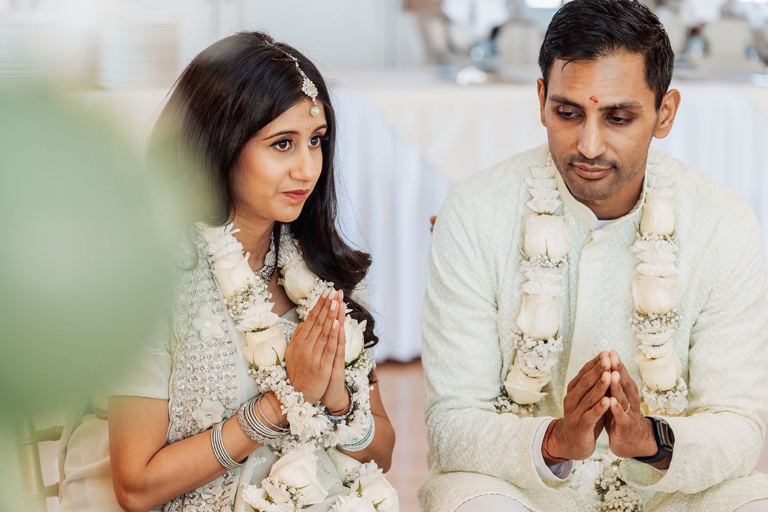 A traditional Indian wedding ceremony with the couple in traditional white and gold attire.