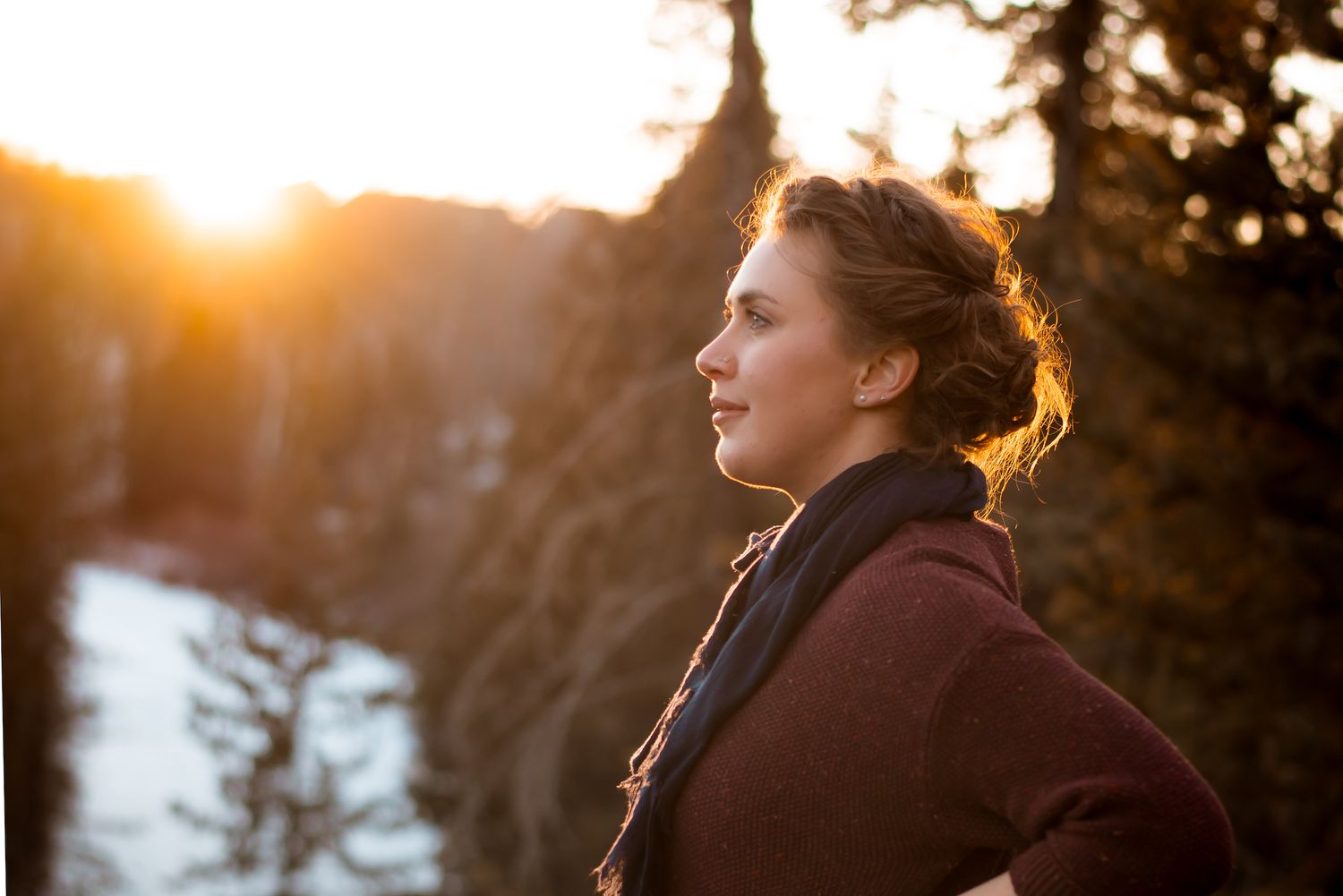 Golden sunlight illuminates profile against winter mountain landscape.