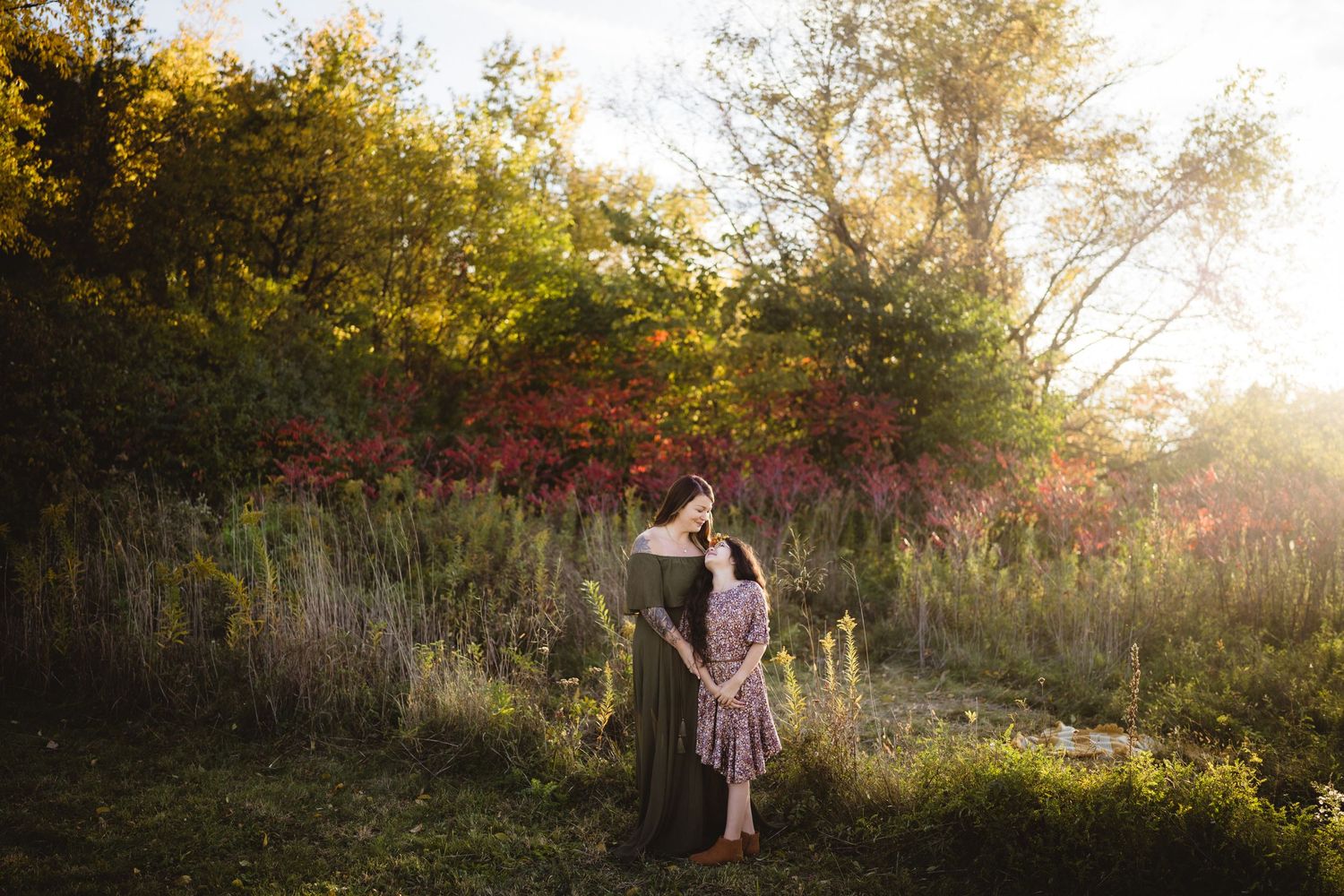 A romantic portrait session in a garden with fall foliage and glowing sunset light.