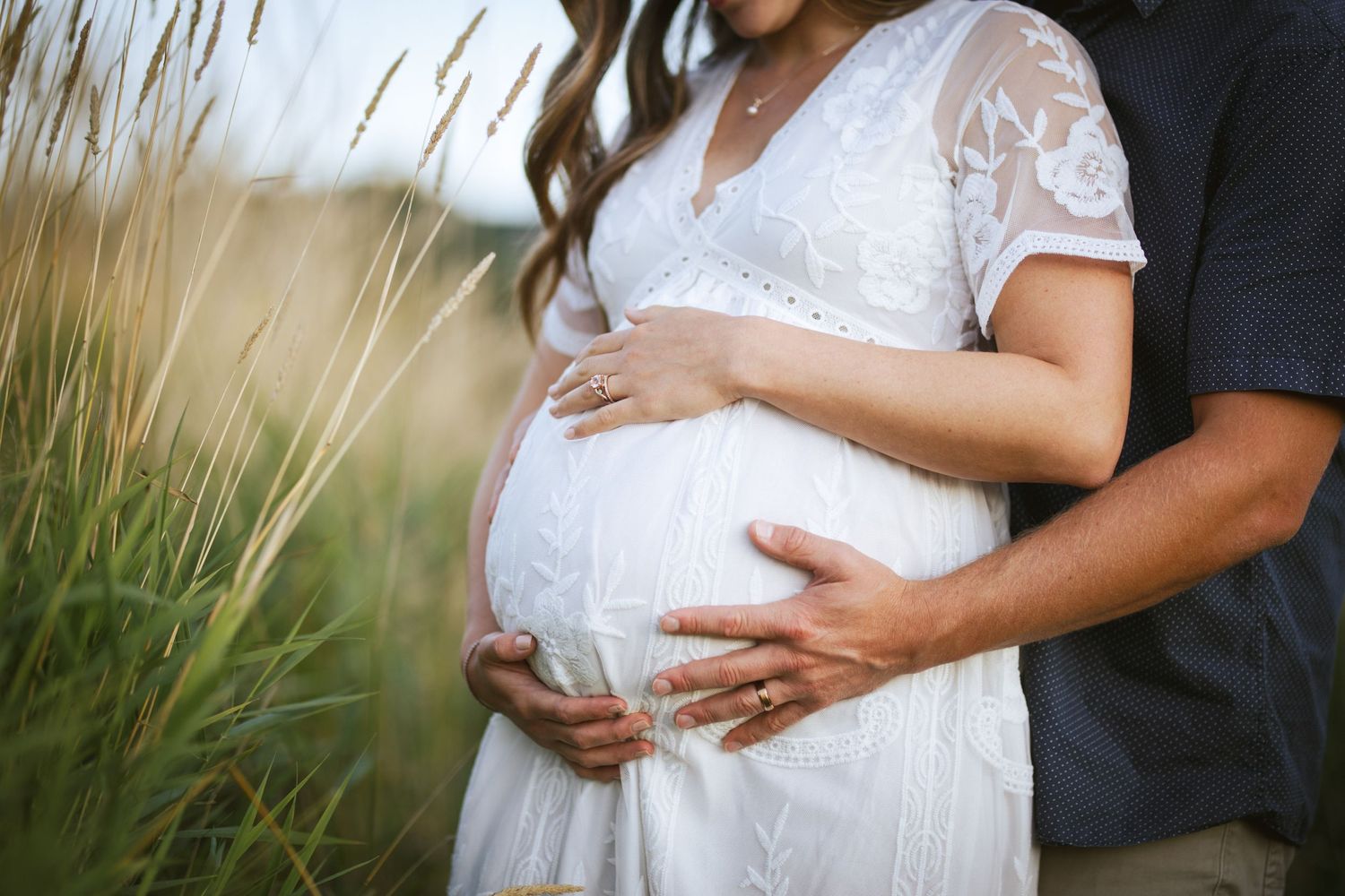 seattle matertnity photographer: a close up a mother's pregnant belly being held by her and her husband's hands
