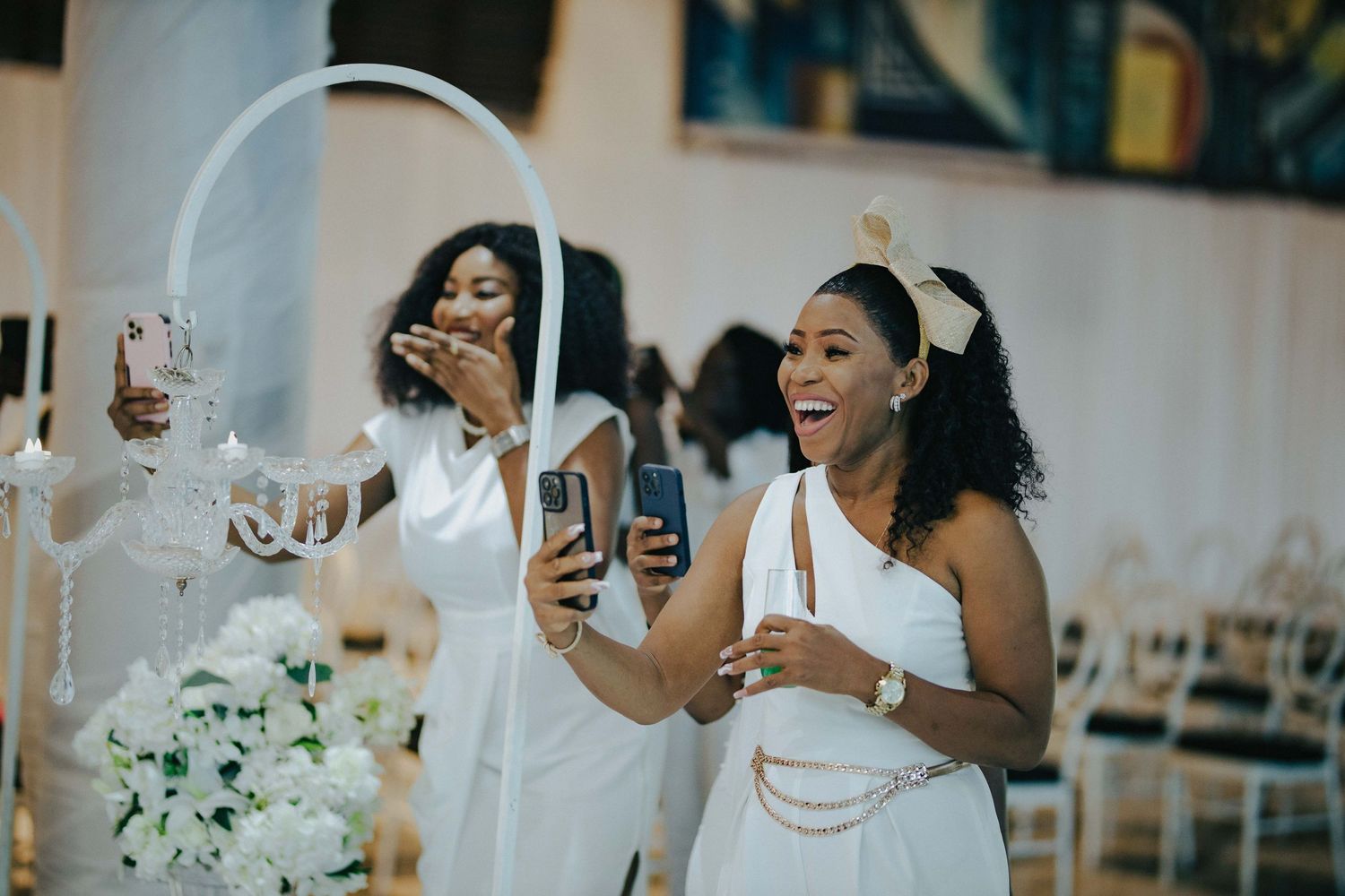Wedding guests enjoying celebrations with phones and drinks at an elegant reception.