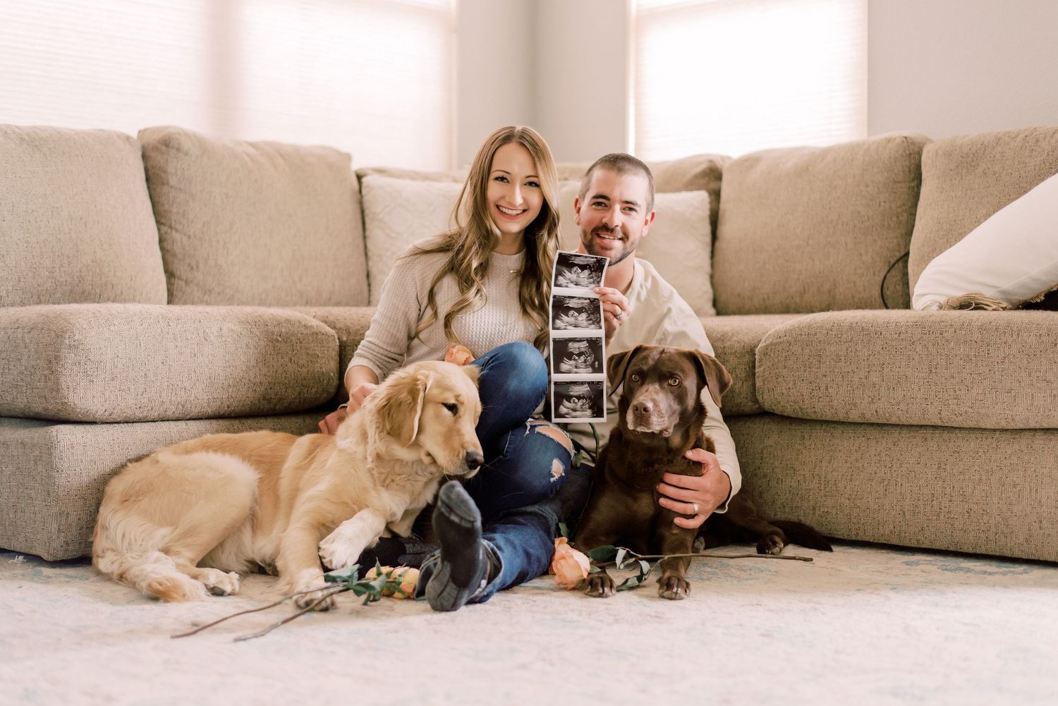 A joyful pregnancy announcement with a couple surrounded by roses, captured in the warmth of their Columbia, MO home