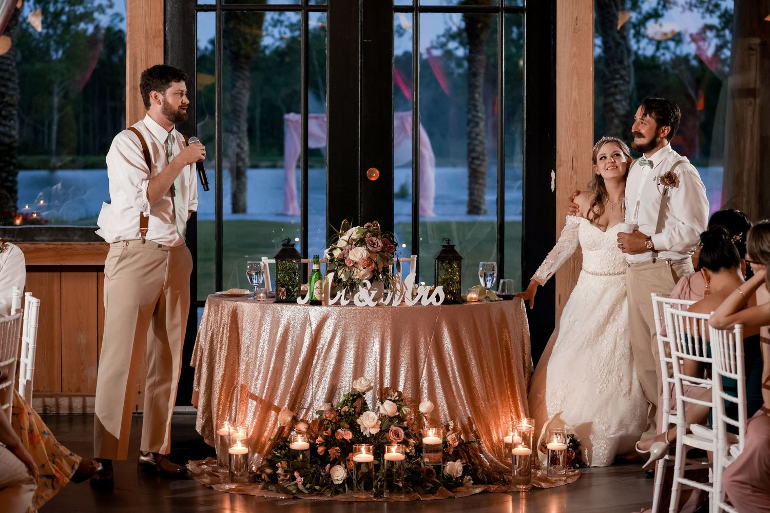 Wedding reception setup with romantic candlelight and dancing in the background.