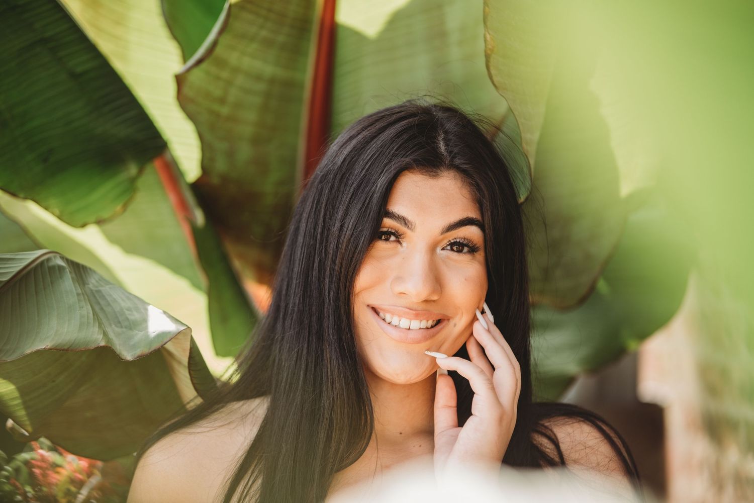 Close up portrait with soft green foliage in background.