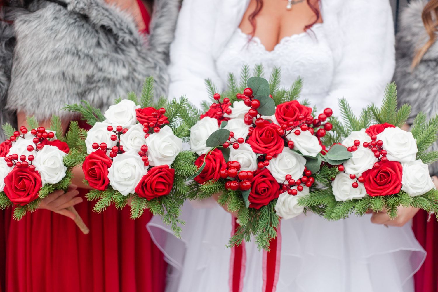 Wedding floral arrangement with red and white roses decorating ceremony space.