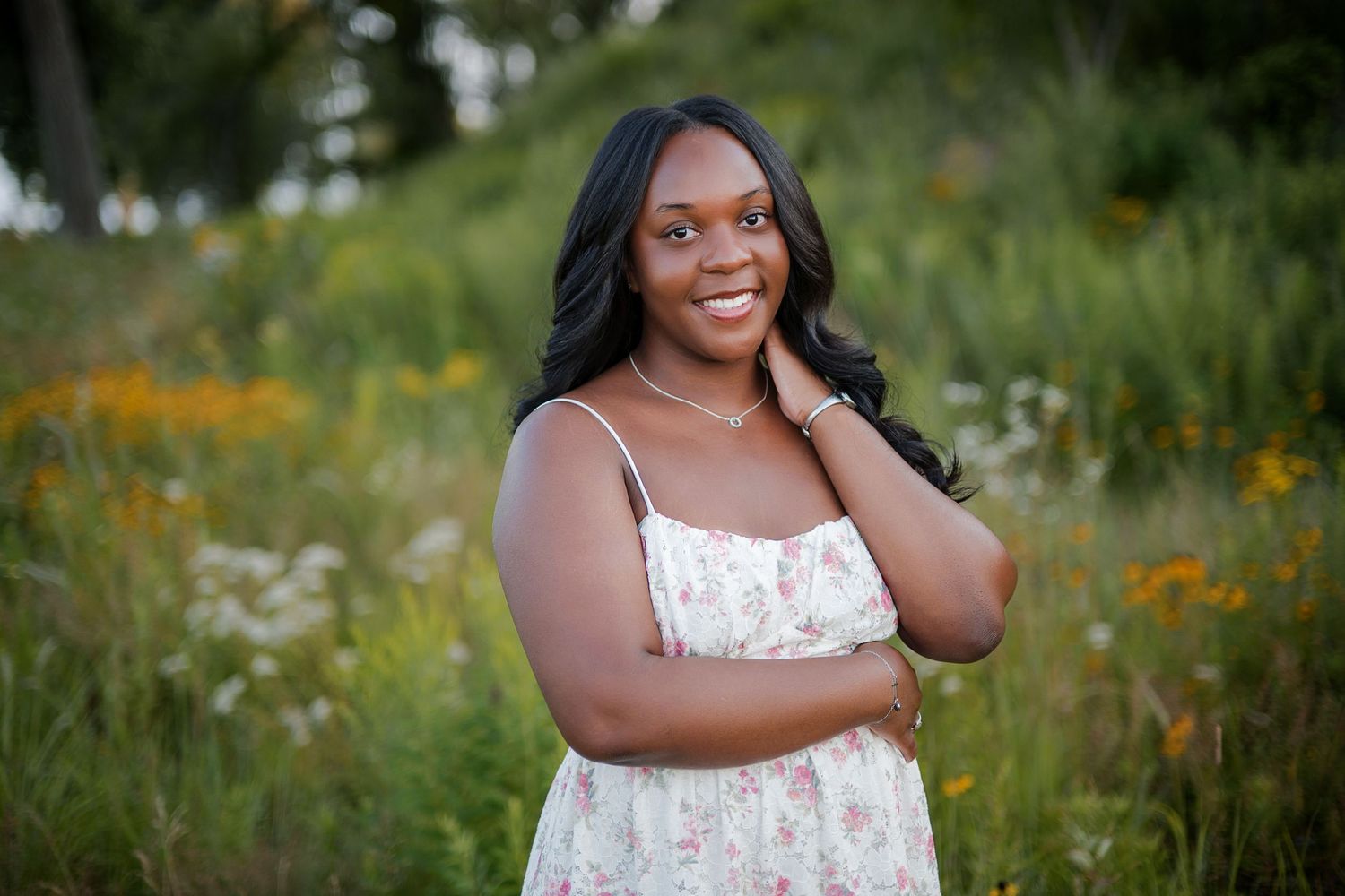 Milwaukee High School Senior in floral sundress smiling in a wildflower meadow during golden in Sheboygan at Lake Michigan