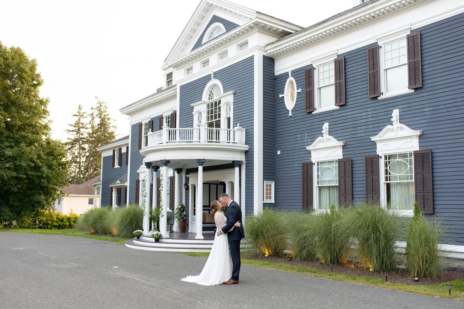 Classic navy blue colonial mansion with white trim and grand pillared entrance.