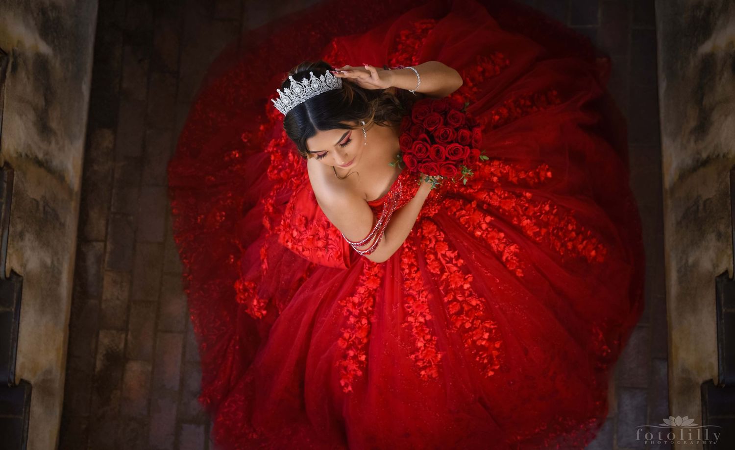 Captivating Quinceañera showcasing her radiant red dress during a photoshoot