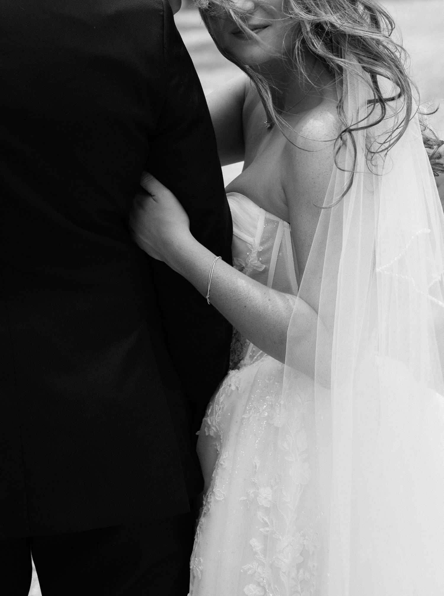 Black and white wedding photograph showing romantic close-up dance moments between newlyweds in elegant attire.