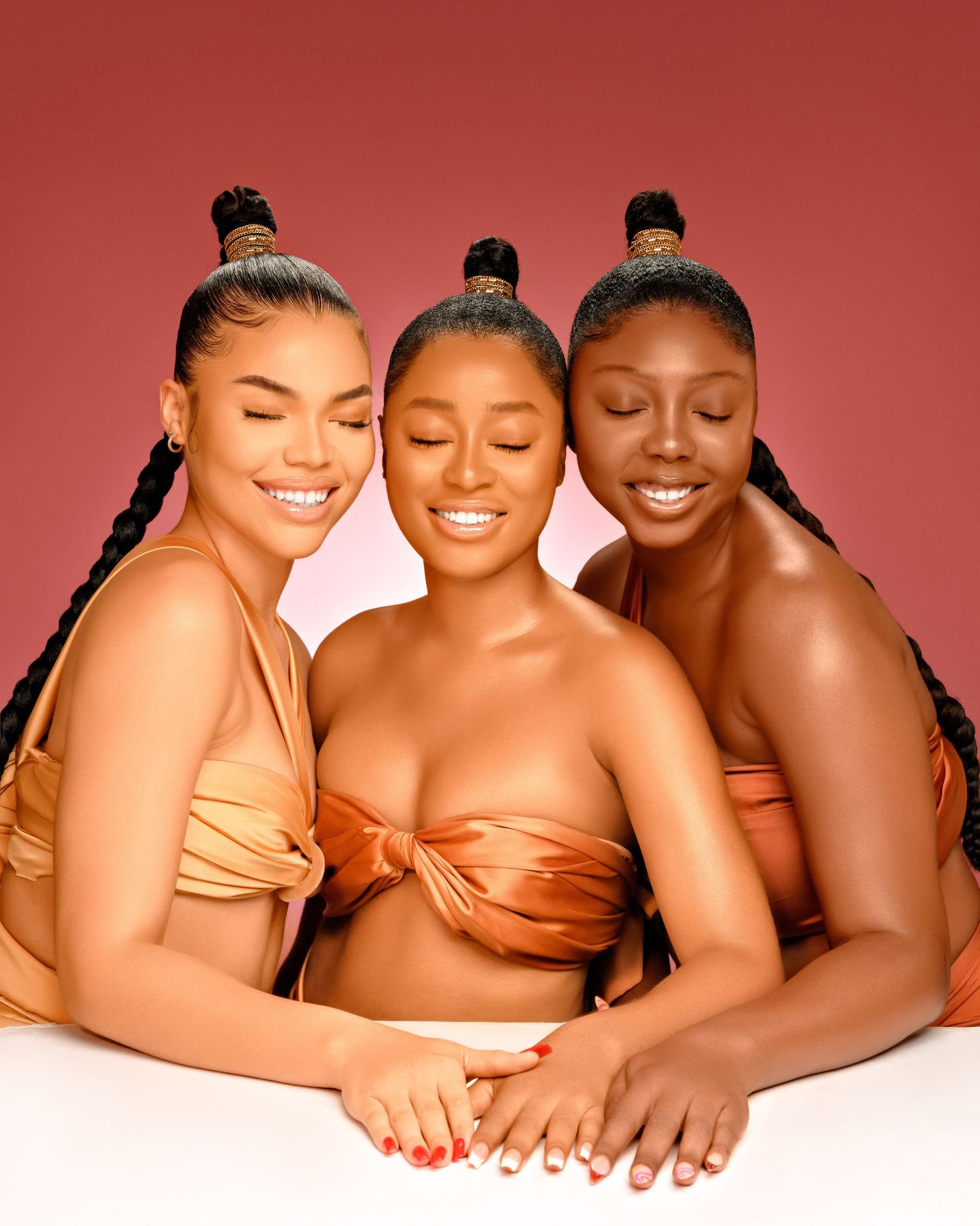 A model poses with beauty and skincare products against a red backdrop showing off various cosmetic items and packaging.
