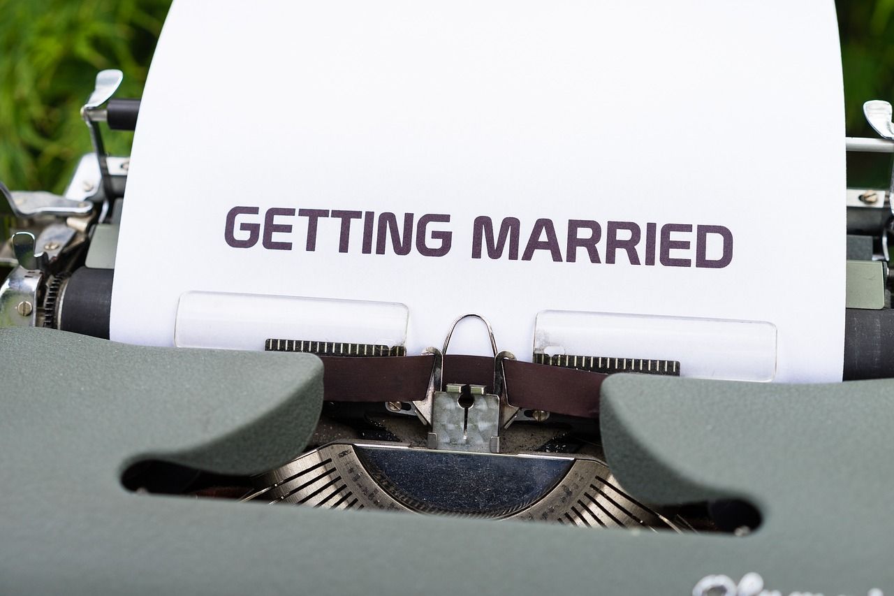 The words 'Getting Married' typed on white paper in a vintage typewriter with green background.