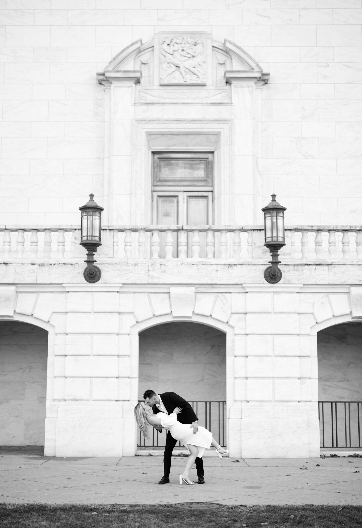 A romantic portrait of a couple smiling together, with the girl in white and soon to be groom in black suit.