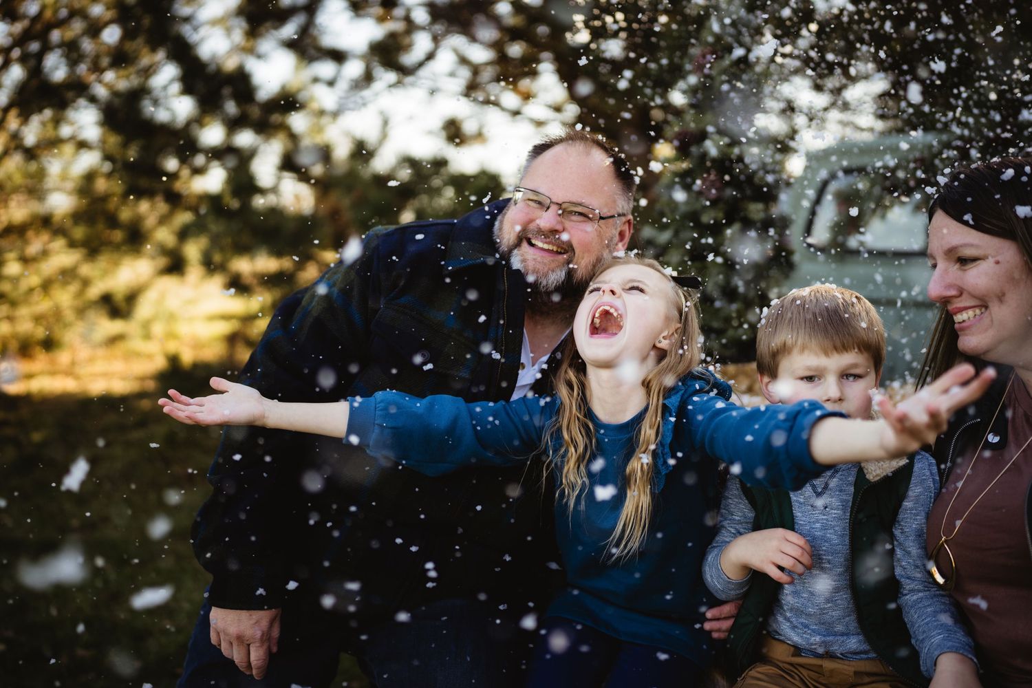 Joyful moment captured of people playing in falling snow at sunset.