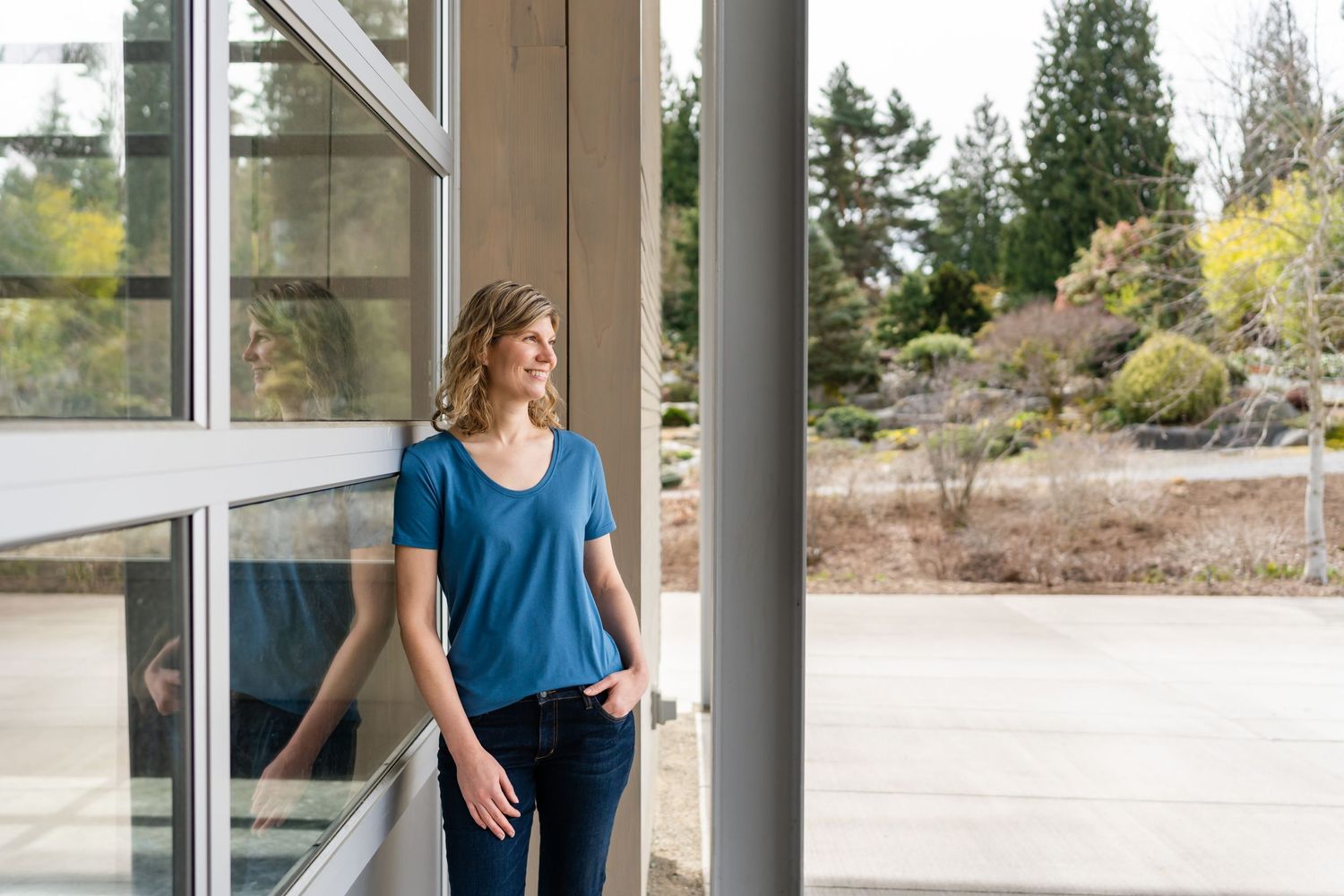Search By Inseam founder posing by a wall, with a reflection, at Bellevue Botanical Garden.