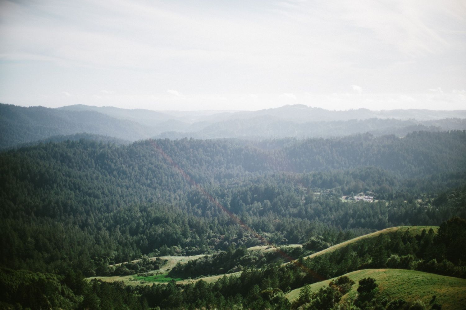 A sweeping vista of forested mountains and valleys stretching into the misty distance.