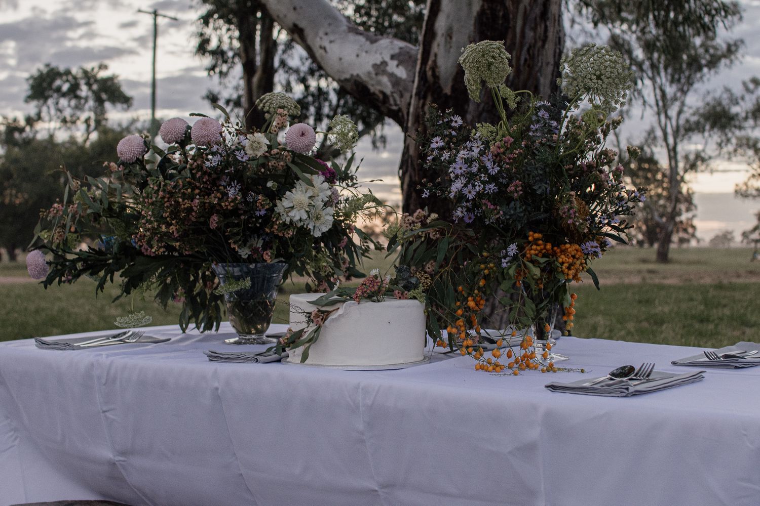 Wedding table with cake and flowers in a rural landscape