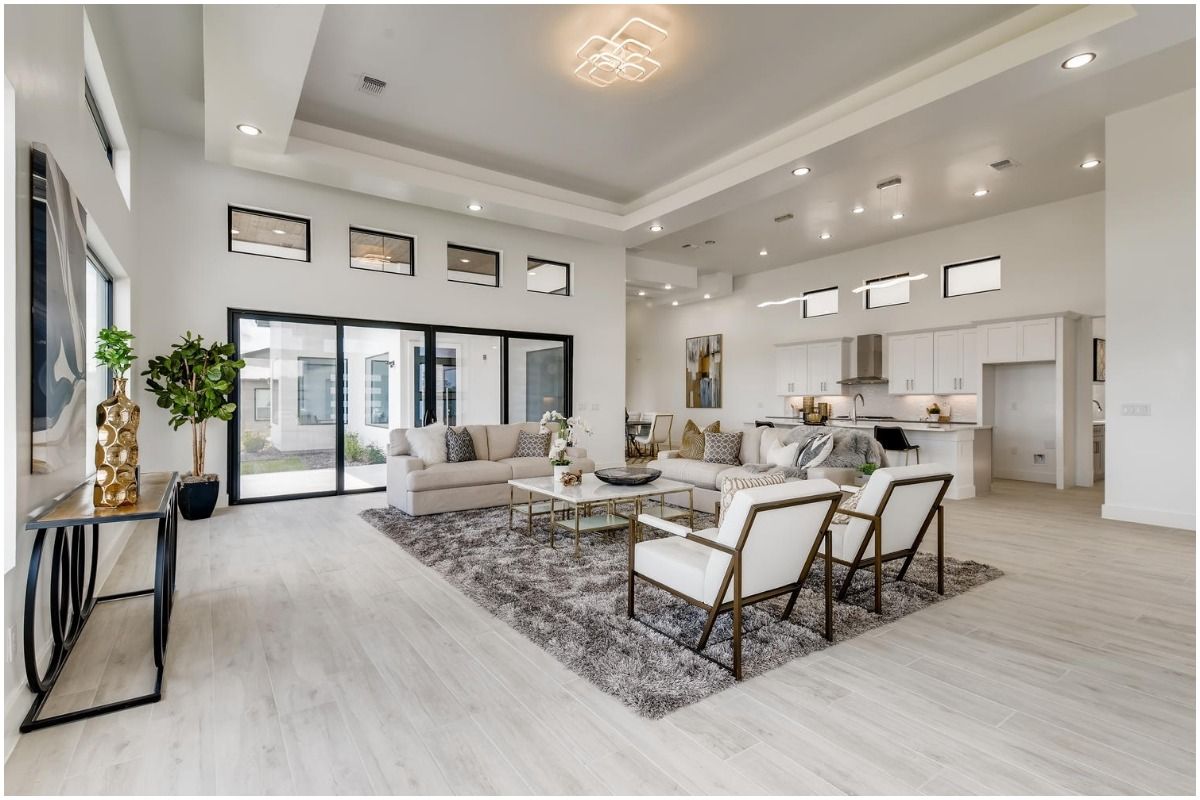 Luxurious modern living space with white walls, recessed lighting, and contemporary furniture arrangements.
