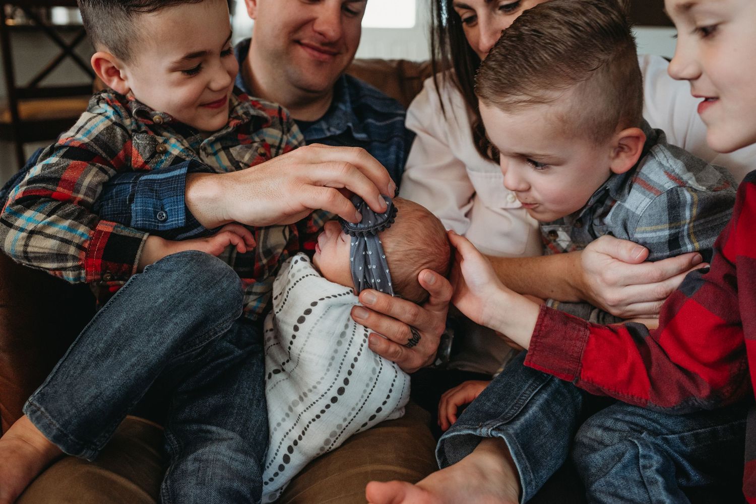 Group huddles together on couch examining a football with excitement.