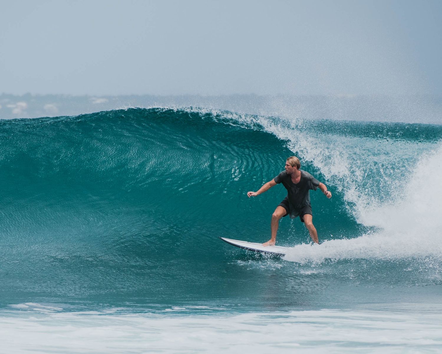 Skilled surfer carves through a perfect barrel wave in crystal clear waters.