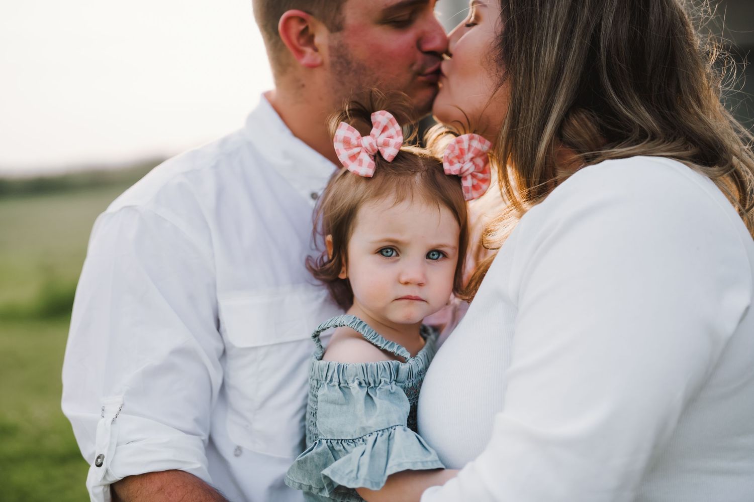 family of three, parents kissing
