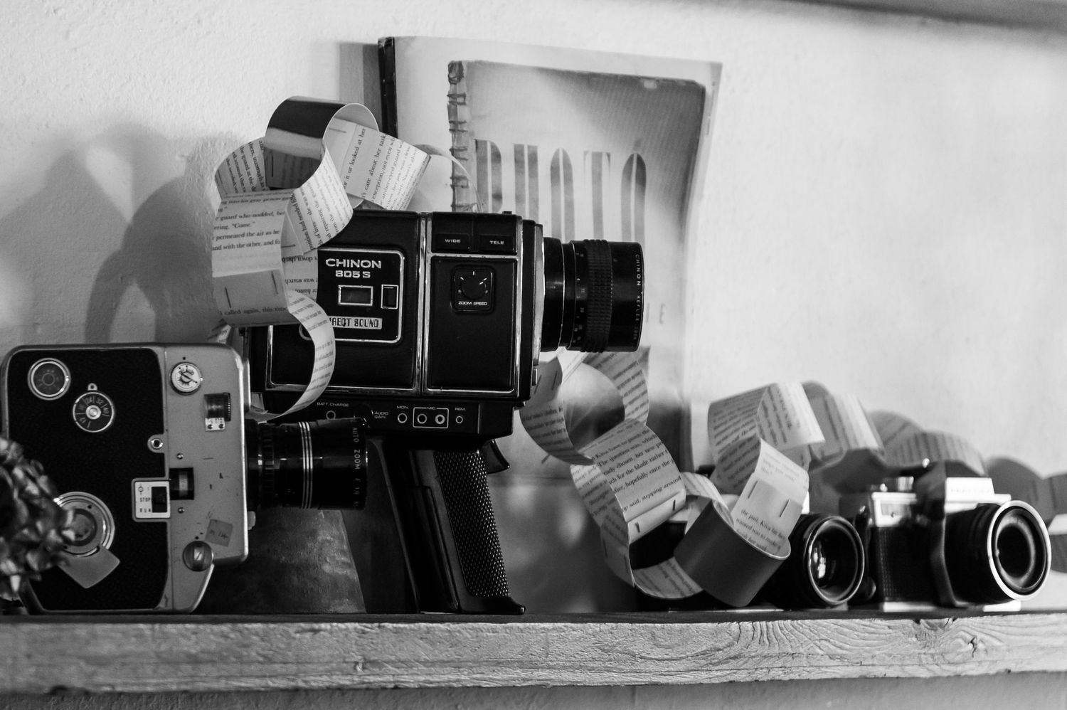 Black and white composition of vintage cameras arranged in a row.