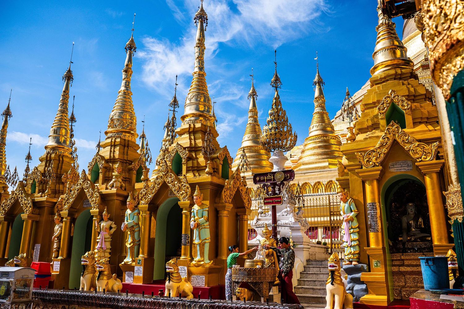 Golden spires and stupas of Shwedagon Pagoda glisten against blue sky in Yangon, Myanmar.