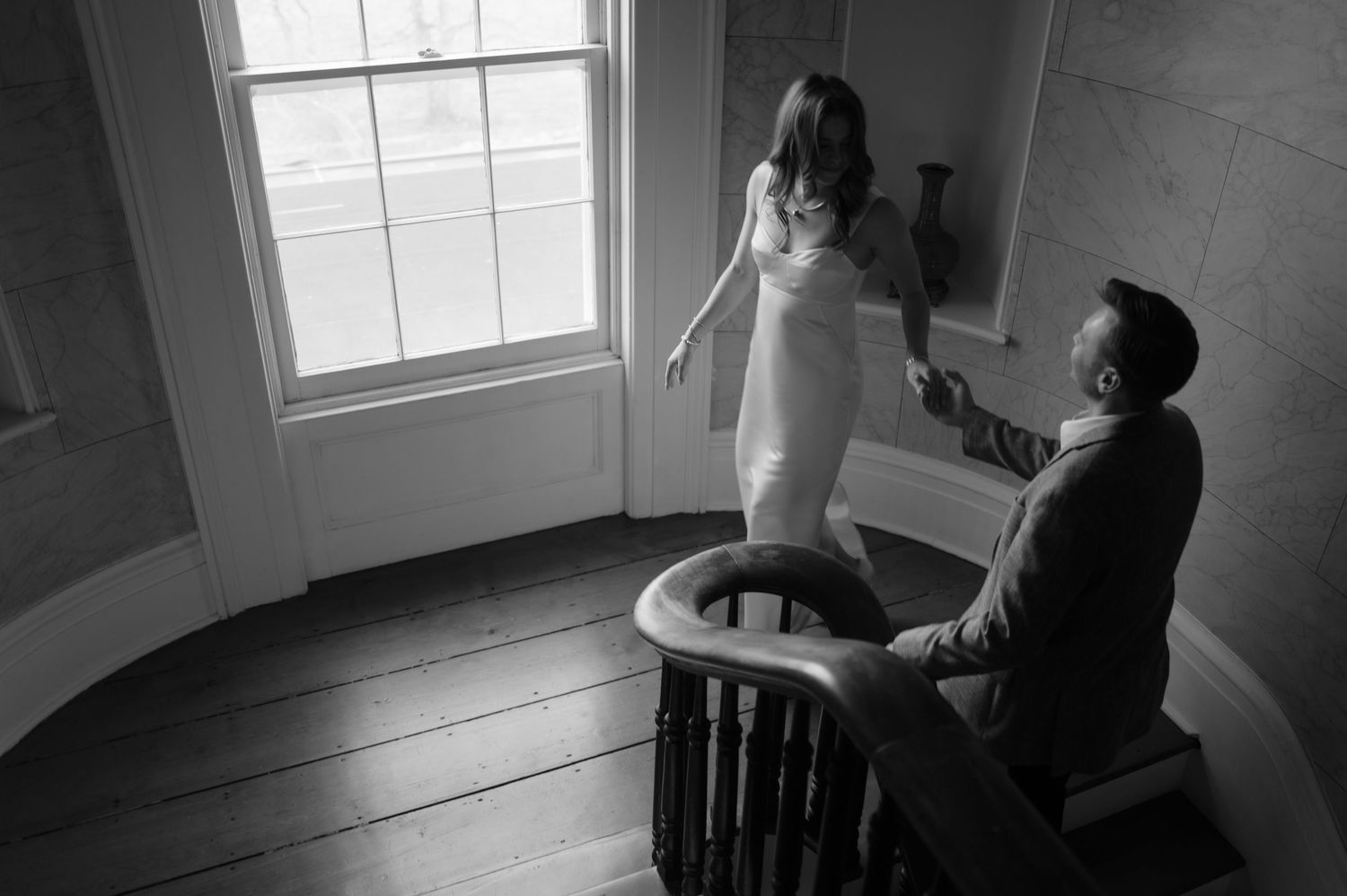 A black and white photo sequence shows a couple dancing together in an elegant room with windows.