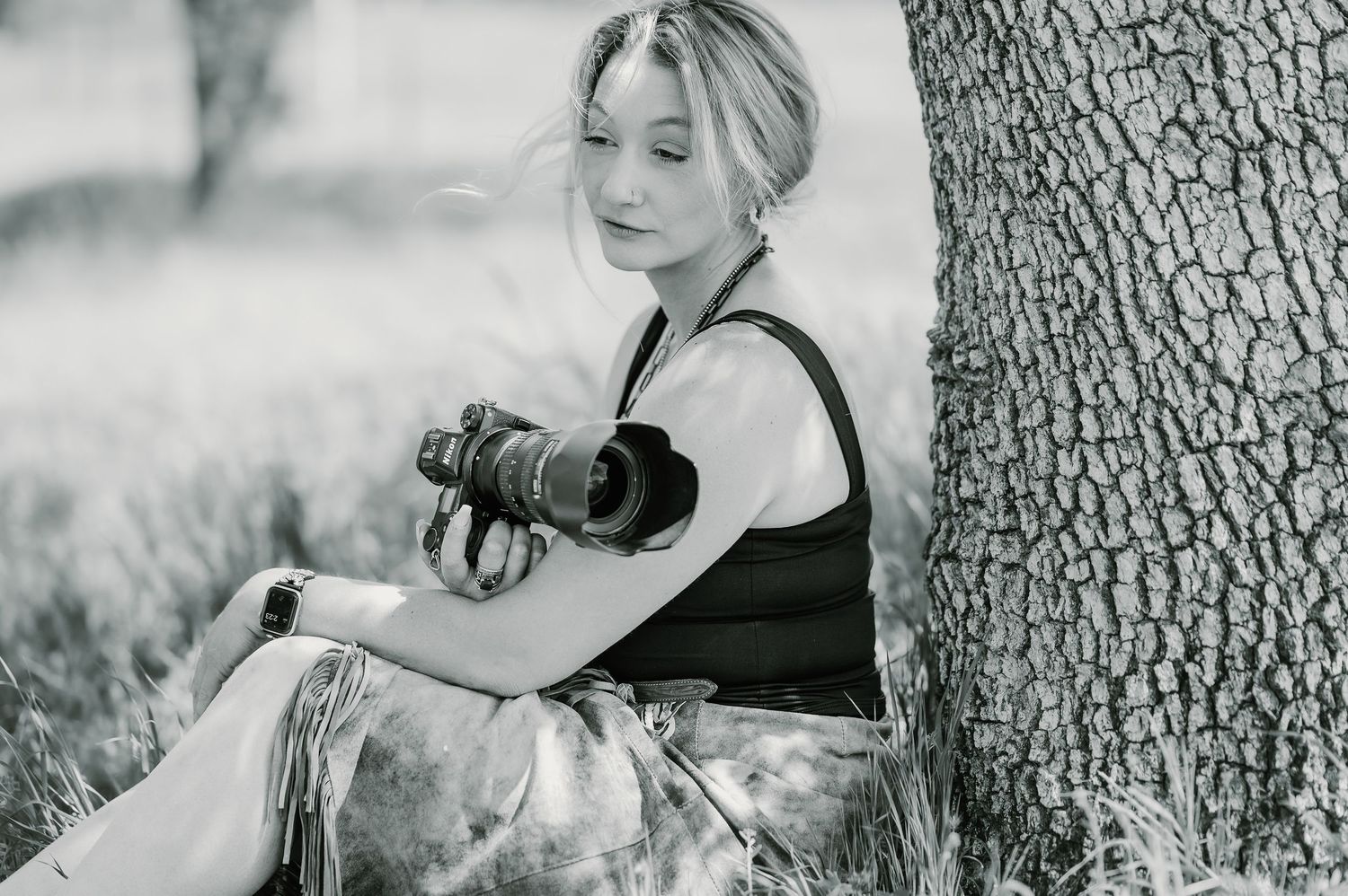 A dreamy black and white portrait series showing someone in a black top and light blonde hair looking over their shoulder.