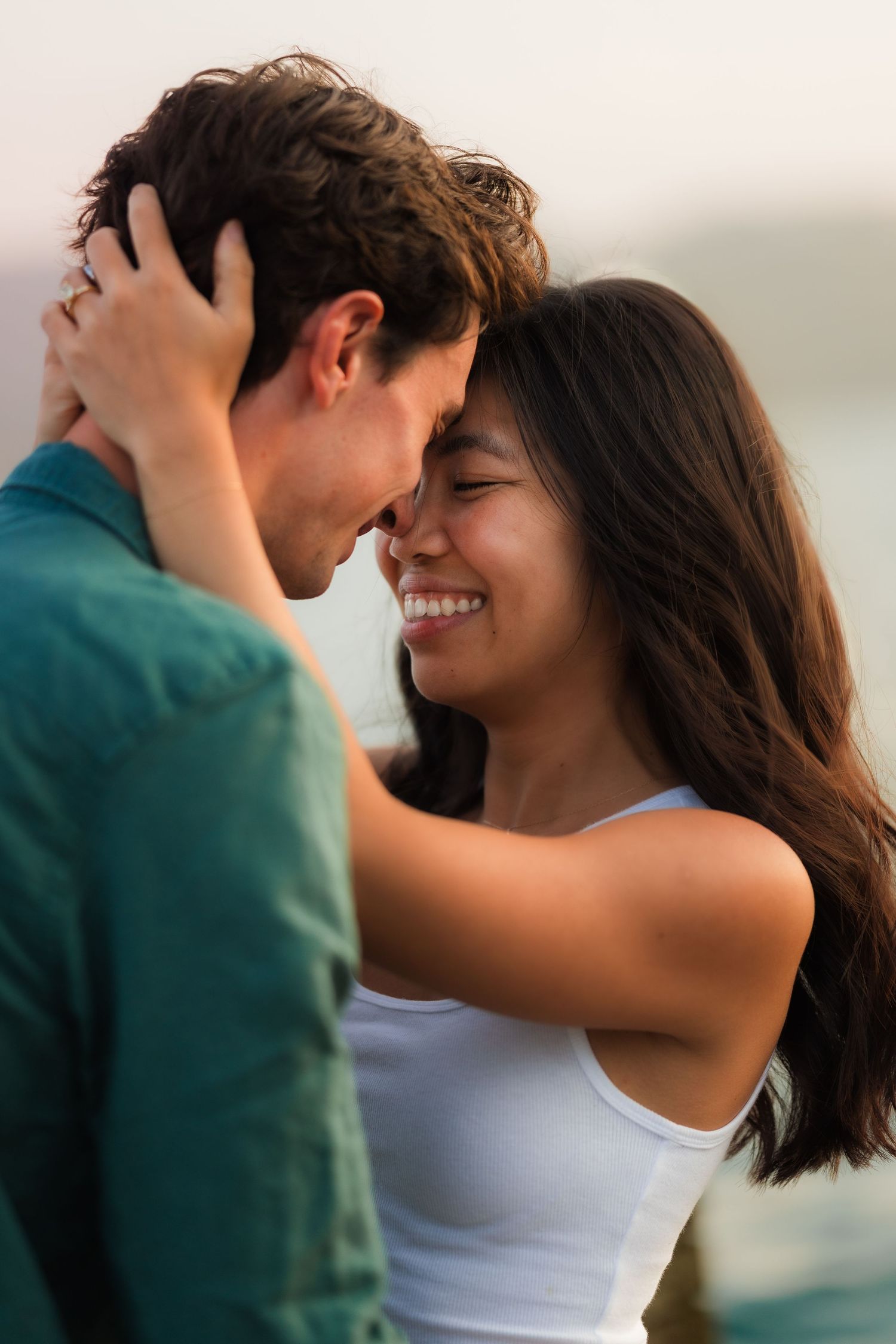 A romantic proposal scene on a wooden dock overlooking a misty mountain lake at sunset.
