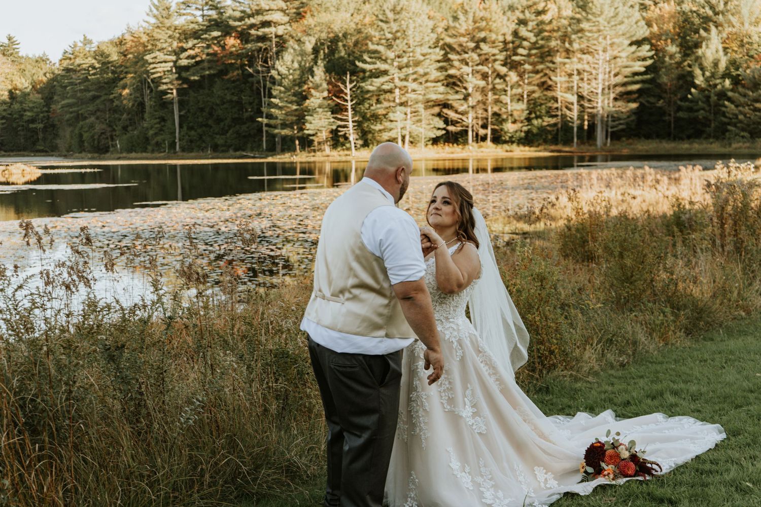 Wedding ceremony takes place under a rustic wooden pavilion with exposed beams and scenic view through archway in background.