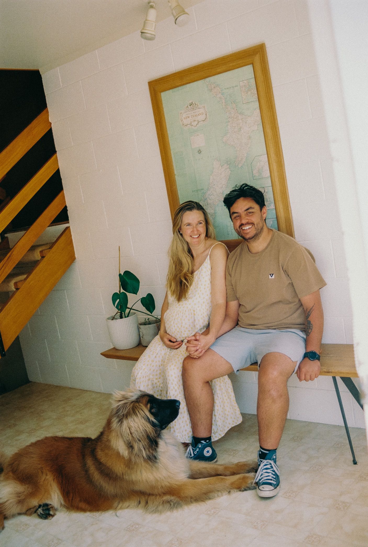 A series of four photos showing a couple sitting on the floor with their brown dog in what appears to be a home setting.