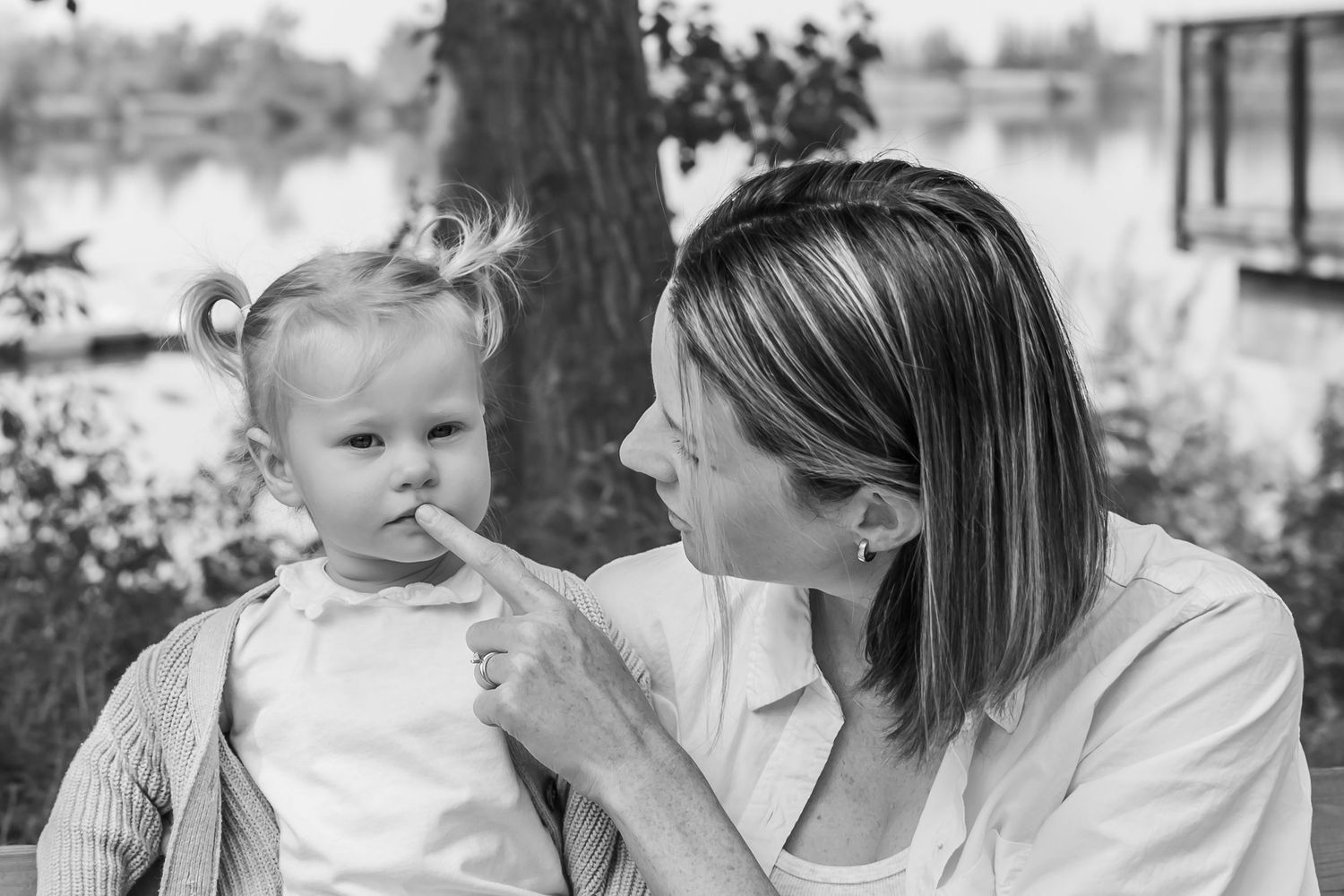 Black and white collage of tender moments shows intimate parent and child interactions at sunset by the water.