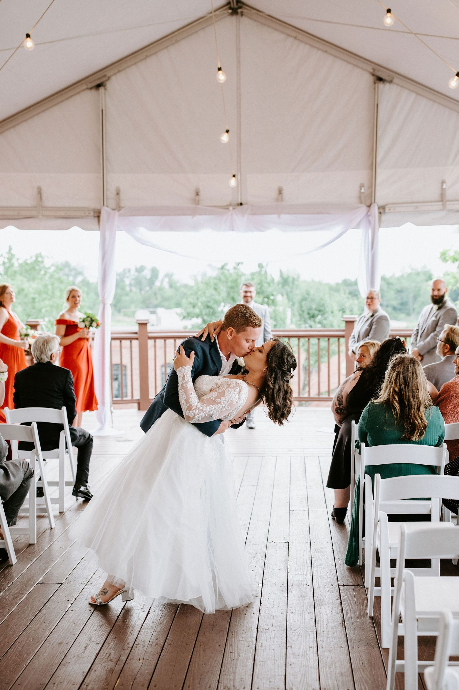 Sequence of five photos showing a wedding party dancing under a white tent on a wooden deck during a reception.